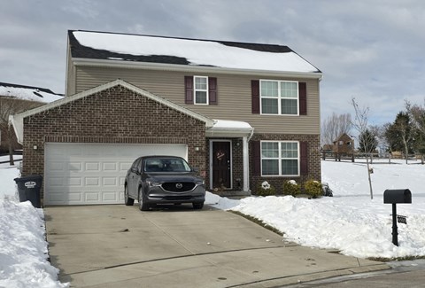 A house with a car parked in front of it.